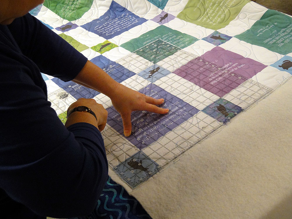 Marybeth Tawfik squaring up the quilt.